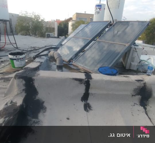 גג עם חומרי איטום שחורים ודלי צבע